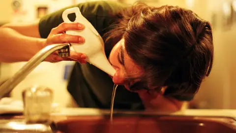 Una mujer lavándose la nariz con una 'Neti Pot', vasija especial para ello Una mujer lavándose la nariz con una 'Neti Pot', vasija especial para ello