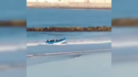 Los bañistas graban a una treintena de personas llegando en patera a una playa de Cádiz Los bañistas graban a una treintena de personas llegando en patera a una playa de Cádiz