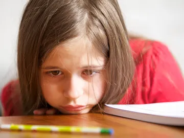 Niña distraída con un lapicero Niña distraída con un lapicero