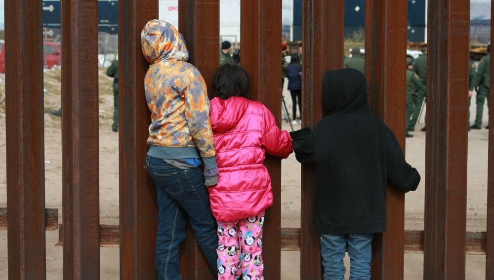 Un grupo de niños observan a agentes de migración de Estados Unidos