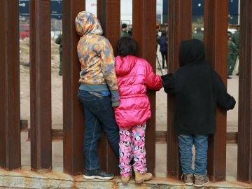 Un grupo de niños observan a agentes de migración de Estados Unidos