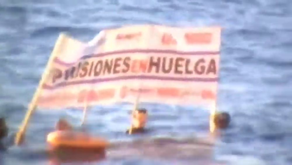 Funcionarios de prisiones se bañan con pancartas en la playa frente a la residencia de Sánchez
