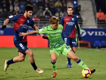 Canales intenta proteger el balón ante la defensa del Huesca