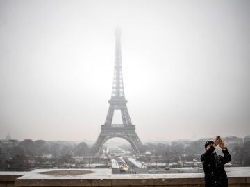 Un turista se toma una foto delante de la Torre Eiffel 