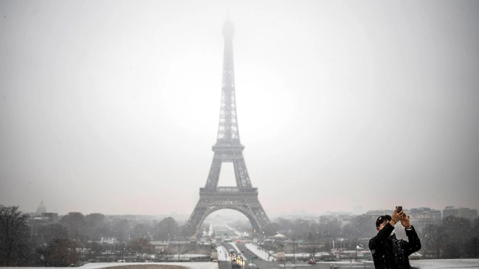 Un turista se toma una foto delante de la Torre Eiffel 