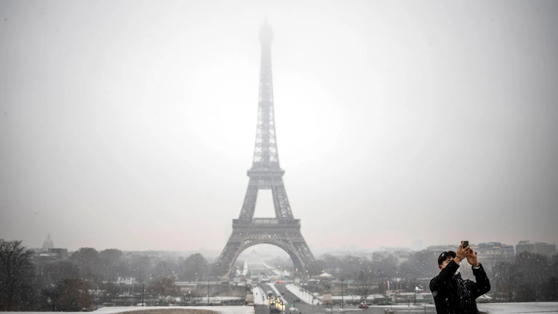 Un turista se toma una foto delante de la Torre Eiffel Un turista se toma una foto delante de la Torre Eiffel
