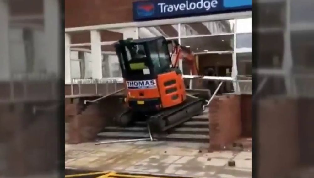 Un trabajador enfurecido estrella su excavadora contra la entrada de un hotel