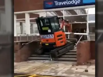 Un trabajador enfurecido estrella su excavadora contra la entrada de un hotel Un trabajador enfurecido estrella su excavadora contra la entrada de un hotel