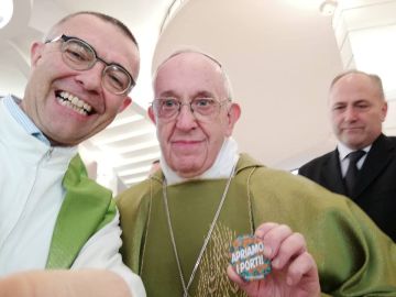 El Papa Francisco posando con una chapa que dice 'Abramos los puertos'