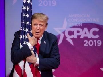 Donald Trump abrazando la bandera estadounidense 