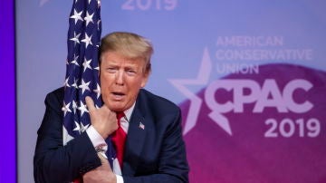 Donald Trump abrazando la bandera estadounidense 