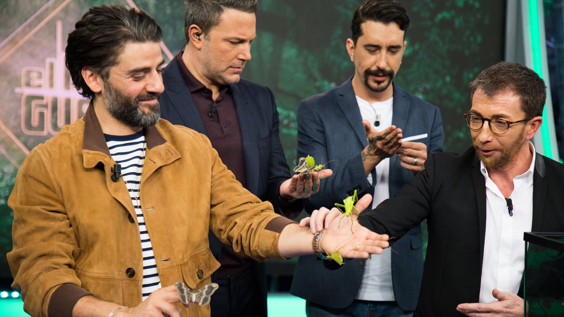 Ben Affleck y Oscar Isaac rodeados de insectos