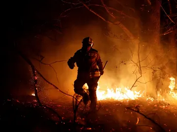 Imagen de un bombero en las labores de extinción de los fuegos en Asturias Imagen de un bombero en las labores de extinción de los fuegos en Asturias
