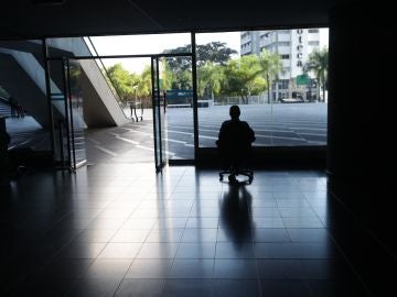  Un hombre mira por la ventana en una oficina sin luz en Caracas, Venezuela.
