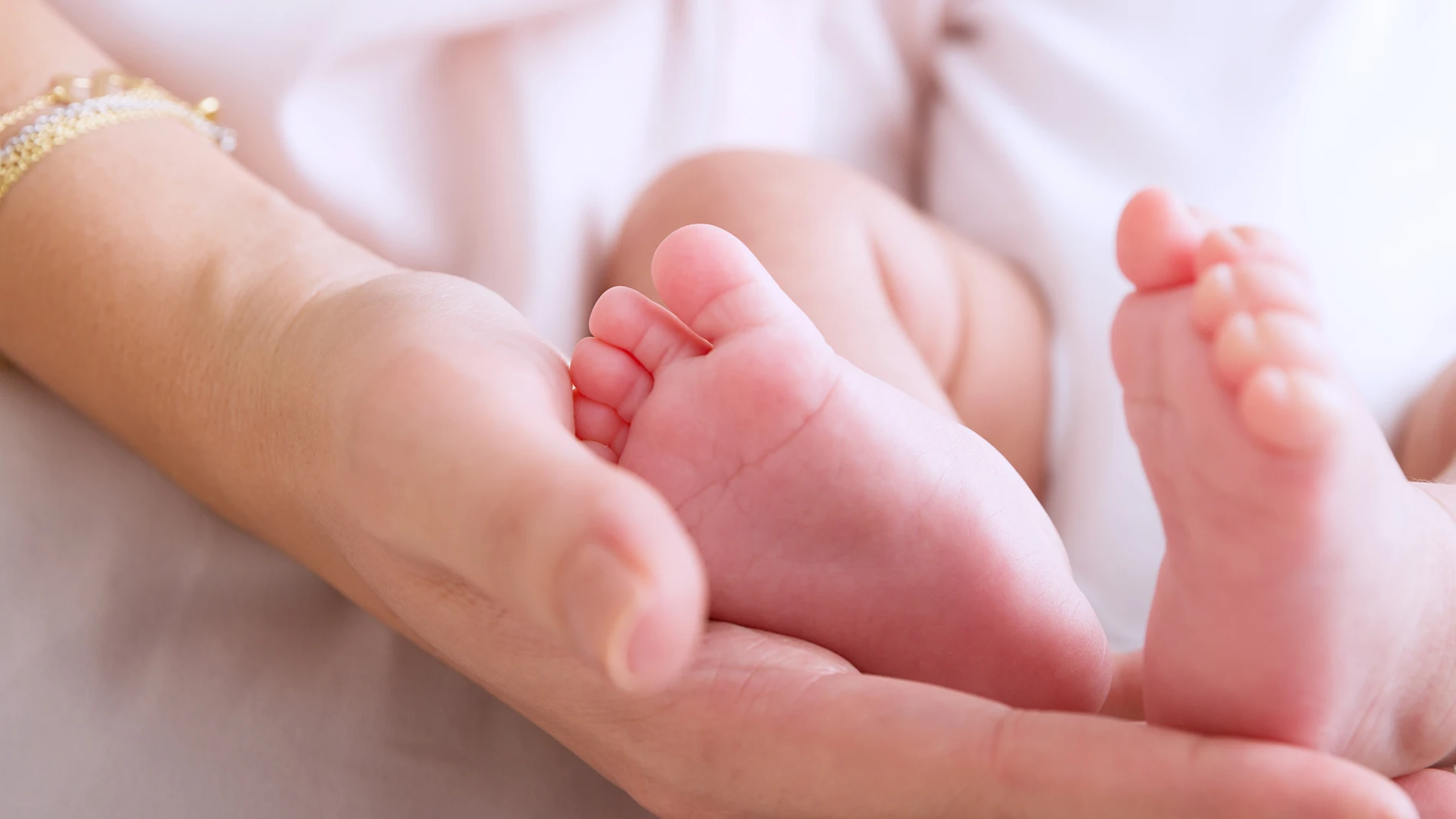 Una madre sosteniendo los pies de su bebé Una madre sosteniendo los pies de su bebé