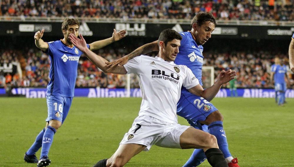 Guedes y Damián pelean por el balón