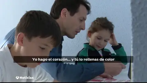 Un padre haciendo los deberes con sus hijos Un padre haciendo los deberes con sus hijos