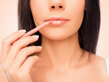 Una mujer se perfila los labios Una mujer se perfila los labios