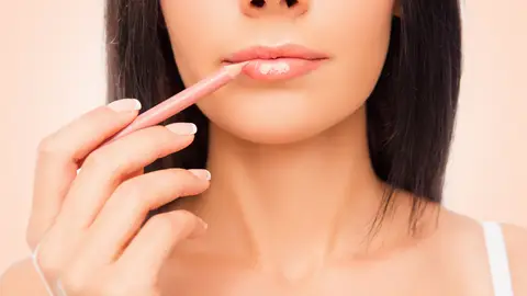 Una mujer se perfila los labios Una mujer se perfila los labios