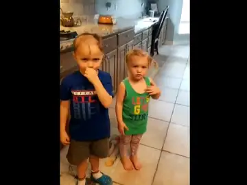 Un niño corta el pelo a su hermana y a él Un niño corta el pelo a su hermana y a él