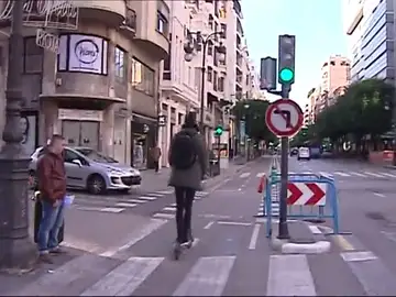 Un ciudadano circula por una calle en un patinete. Un ciudadano circula por una calle en un patinete.