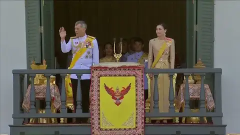 El rey de Tailandia saluda al pueblo junto a su nueva esposa desde el balcón del palacio El rey de Tailandia saluda al pueblo junto a su nueva esposa desde el balcón del palacio
