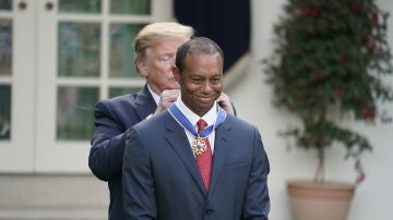 Donald Trump poniéndole la medalla a Tiger