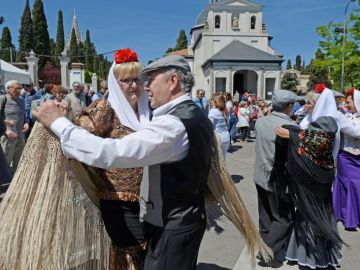 Varias personas bailan chotis en las celebraciones de San Isidro.