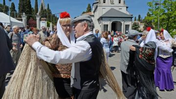 Varias personas bailan chotis en las celebraciones de San Isidro.