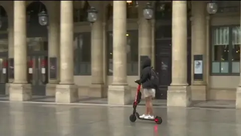 Una mujer en patinete Una mujer en patinete