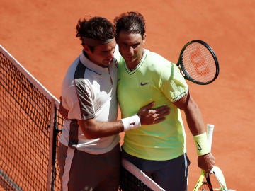 Roger Federer y Rafa Nadal se abrazan después de su partido en Roland Garros