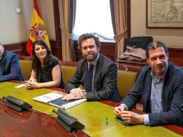 Los representantes de Vox en el Congreso, Pedro Hernández (d), Iván Espinosa de los Monteros y Macarena Olona Choclán (3d), durante la reunión que han mantenido con representantes del PP en la Cámara Baja para avanzar en las negociaciones de gobiernos