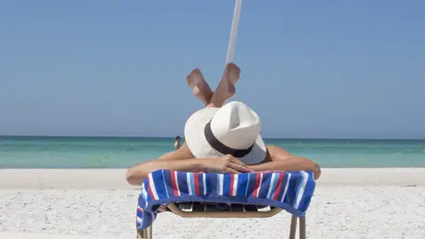 Una mujer toma el sol en una playa Una mujer toma el sol en una playa
