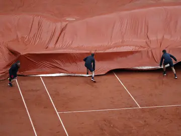 Los operarios de Roland Garros ponen la lona en la Philippe Chatrier Los operarios de Roland Garros ponen la lona en la Philippe Chatrier