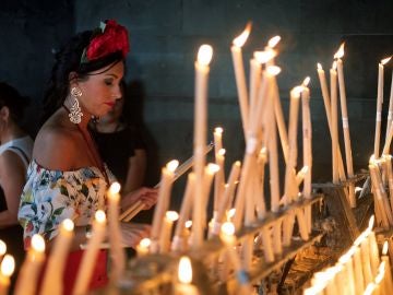 Una rociera coloca una vela en el Santuario de la Virgen del Rocío