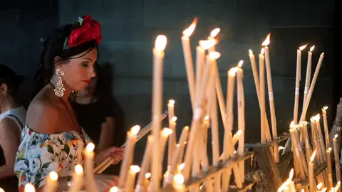 Una rociera coloca una vela en el Santuario de la Virgen del Rocío Una rociera coloca una vela en el Santuario de la Virgen del Rocío