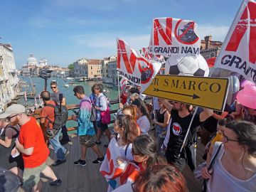 Varias personas marchan con banderas 'No Grandi Navi'