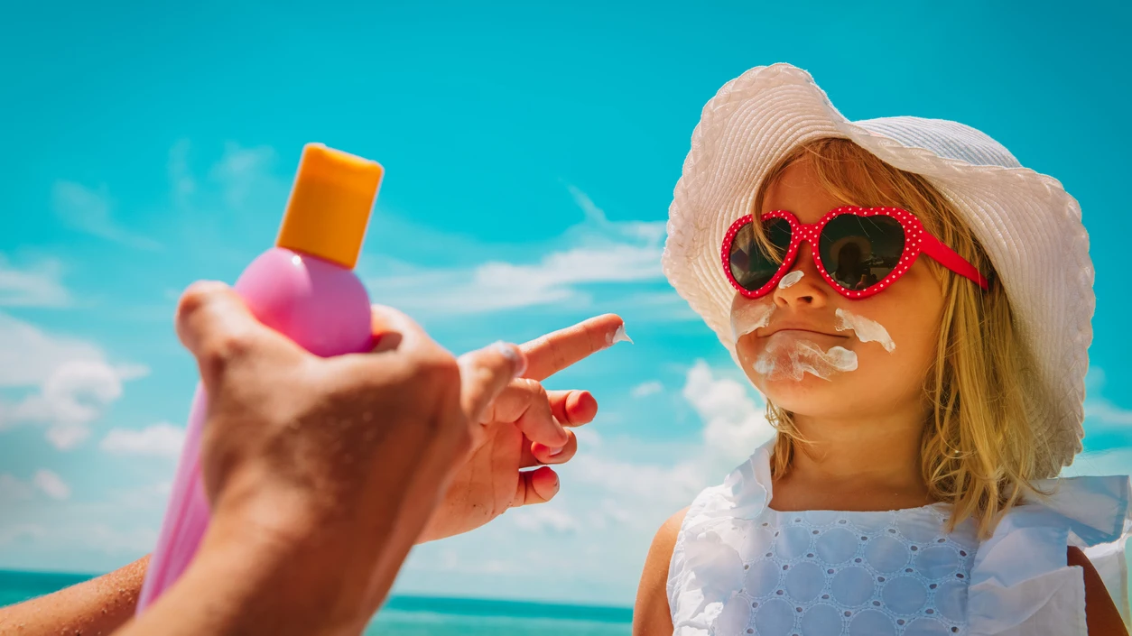 Poniendo crema solar a una niña Poniendo crema solar a una niña