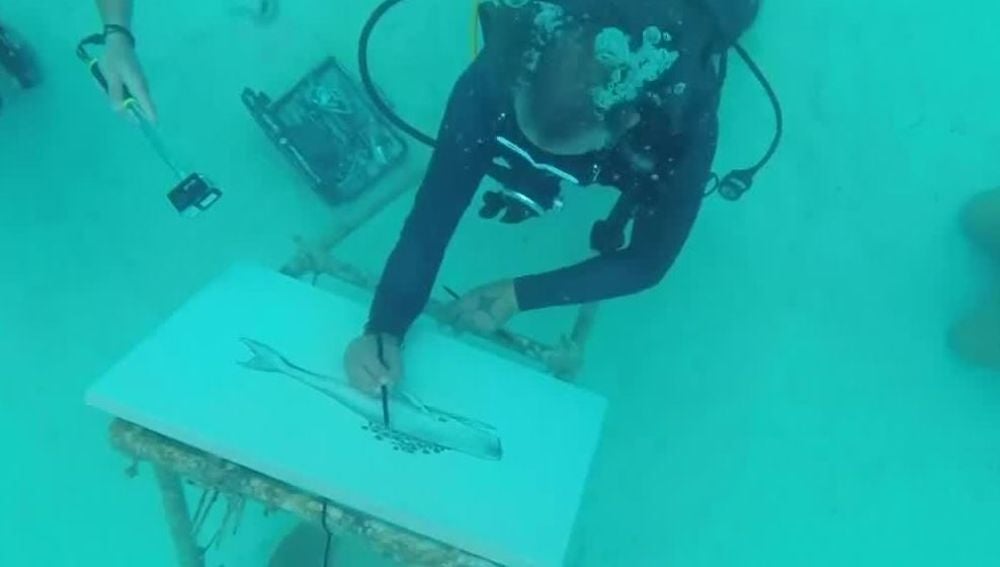 Un artista pintando bajo el agua