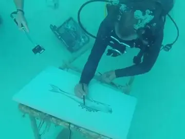 Un artista pintando bajo el agua Un artista pintando bajo el agua