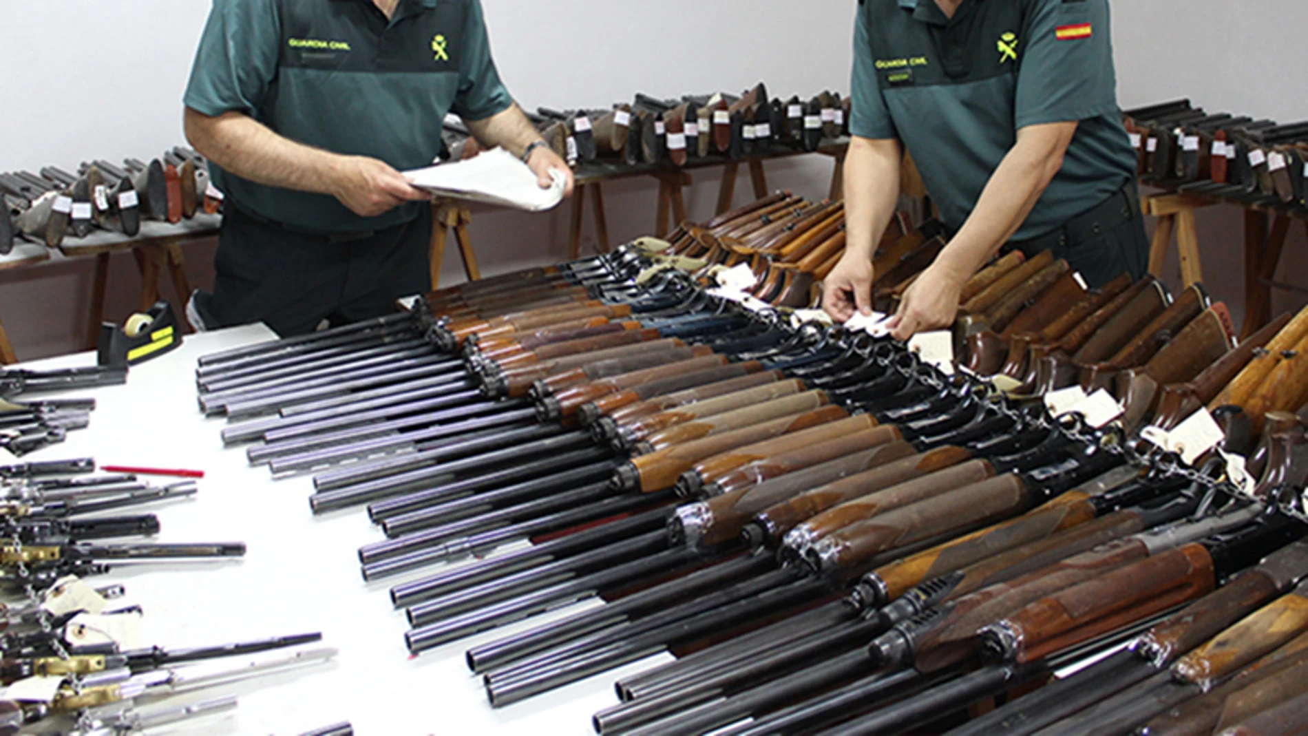 Dos agentes de la Guardia Civil revisan numerosas escopetas y armas Dos agentes de la Guardia Civil revisan numerosas escopetas y armas