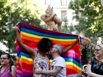 Dos hombres besándose ante la bandera del orgullo gay Dos hombres besándose ante la bandera del orgullo gay