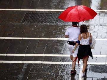 Dos personas se protegen de la lluvia en una de las céntricas calles de Pamplona