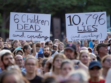 Manifestantes sostienen carteles en los que se leen "6 niños muertos y contando" Manifestantes sostienen carteles en los que se leen "6 niños muertos y contando"