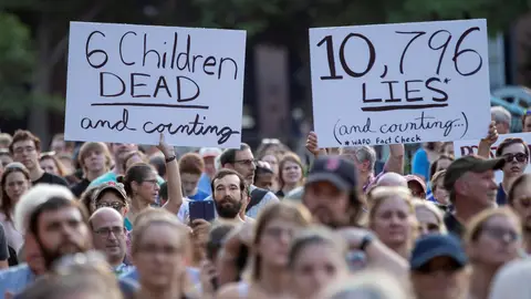 Manifestantes sostienen carteles en los que se leen "6 niños muertos y contando" Manifestantes sostienen carteles en los que se leen "6 niños muertos y contando"