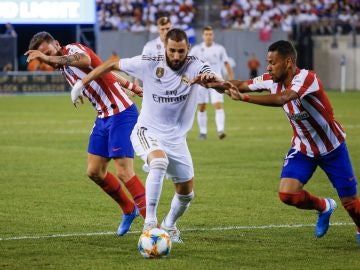 Karim Benzema pelea por el balón durante un partido contra el Atlético de Madrid 