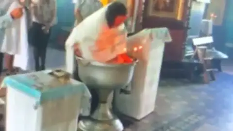 La Iglesia suspende al sacerdote que ofició el violento bautizo que ha dado la vuelta al mundo La Iglesia suspende al sacerdote que ofició el violento bautizo que ha dado la vuelta al mundo