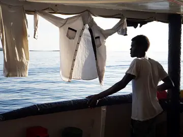 Un migrante mira este domingo desde la cubierta de el buque Open Arms Un migrante mira este domingo desde la cubierta de el buque Open Arms