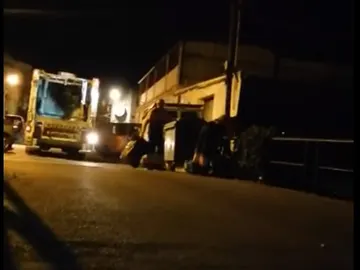 Los trabajadores lanzando las bolsas al arroyo Los trabajadores lanzando las bolsas al arroyo