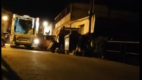 Los trabajadores lanzando las bolsas al arroyo Los trabajadores lanzando las bolsas al arroyo